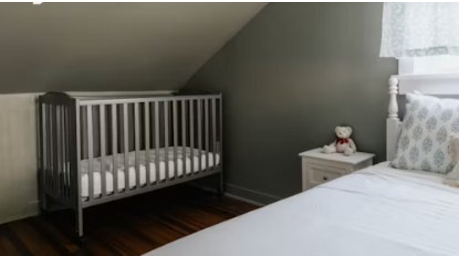 An empty cot with bare mattress in a quiet nursery
