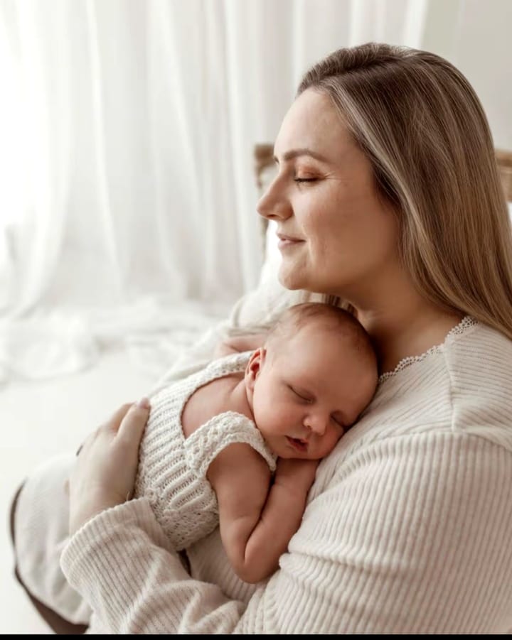 A mum holding her sleeping newborn baby